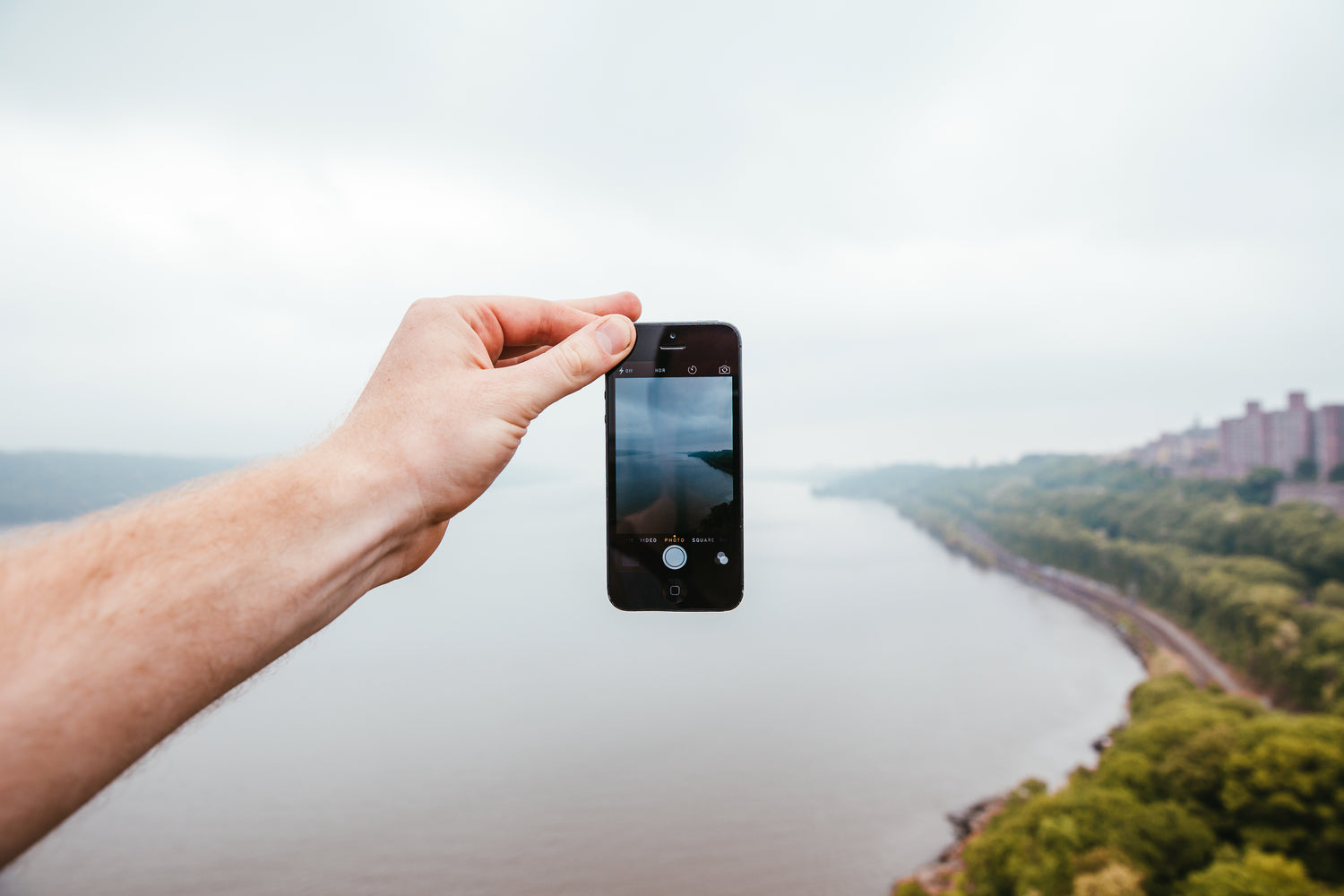 Picture of a hand holding a phone with fingertips in landscape